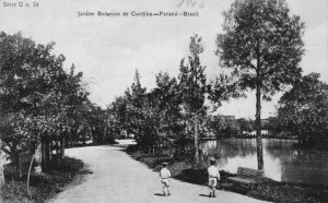 Curitiba - Postal que mostra uma das vias de passeio do Passeio Público, em 1908. Em primeiro plano, um dos bancos colocados por Francisco Fasce Fontana quando era diretor do parque. Em frente ao banco, duas crianças caminham pela via. Postal da Coleção Julia Wanderley. Acervo: Instituto Histórico e Geográfico do Paraná / Diretoria de Patrimônio Histórico, Artístico e Cultural / Fundação Cultural de Curitiba.